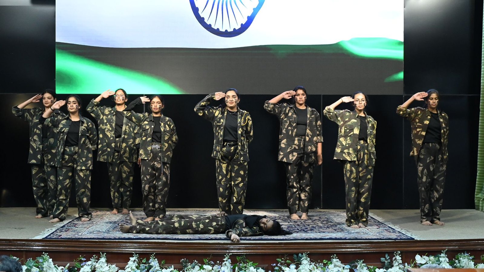 Cadets salute before the tricolour on stage